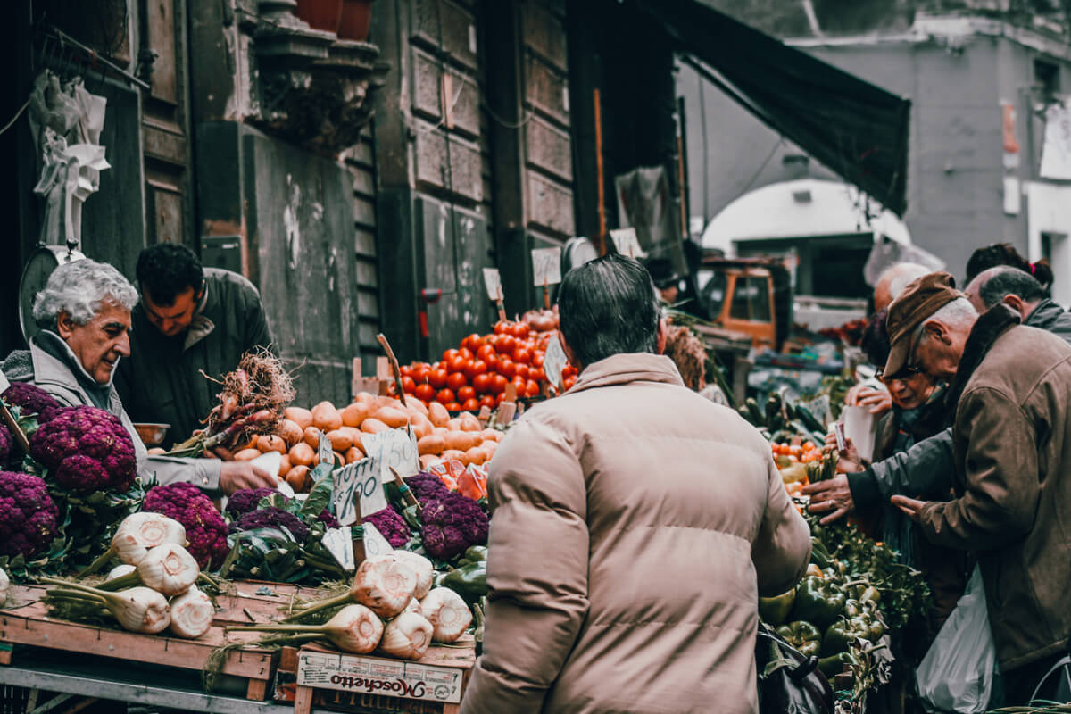 People buying fruits in the market in sicily