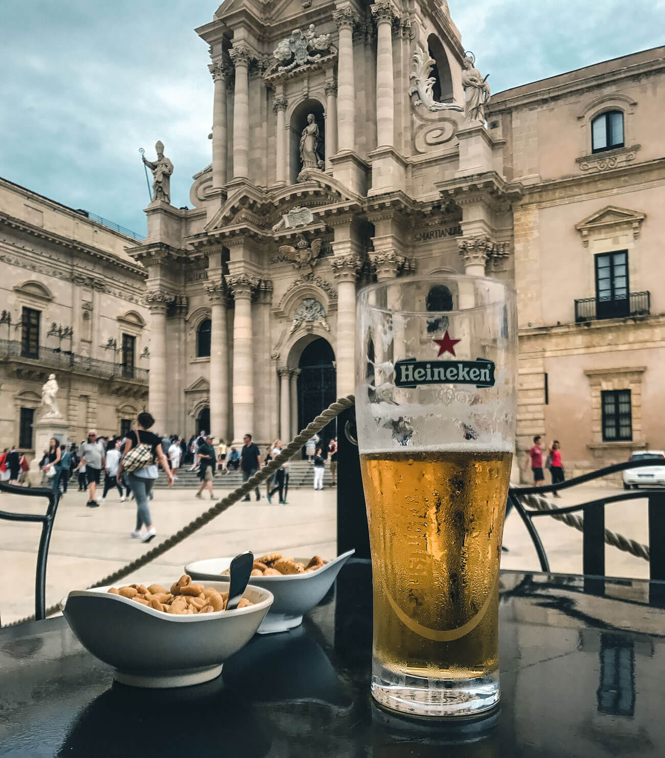 Sitting in bar drinking beer in-front of Ortigia Cathedral in Syracuse 